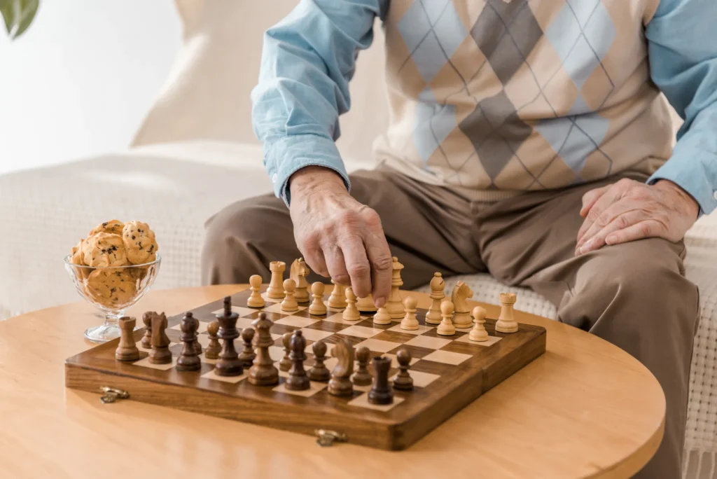 Senior man playing chess, reflecting cognitive engagement at Cura Living.