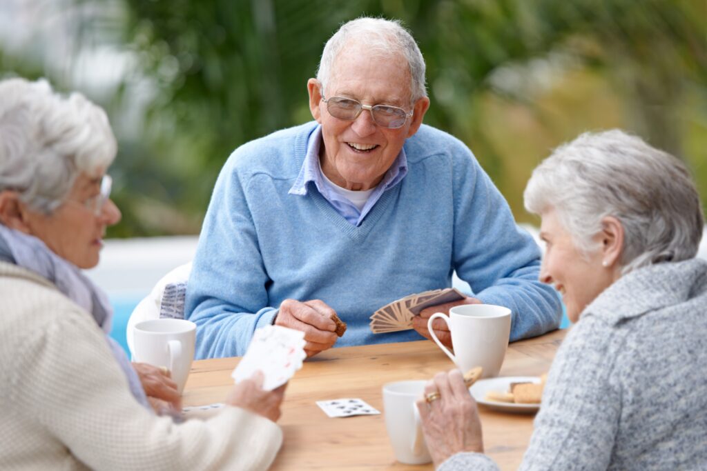 Seniors socializing over a standing card game